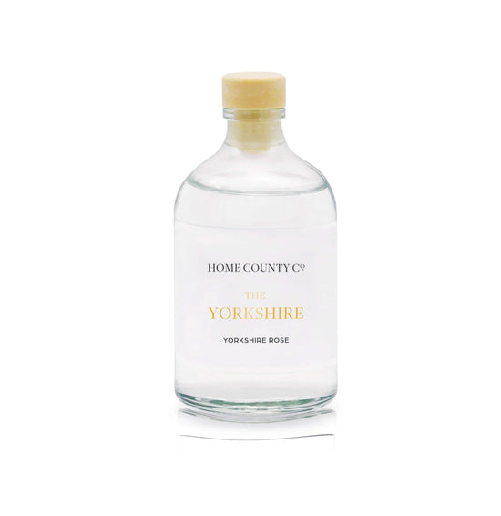 A Yorkshire rose reed diffuser refill is shown in a recyclable glass bottle
