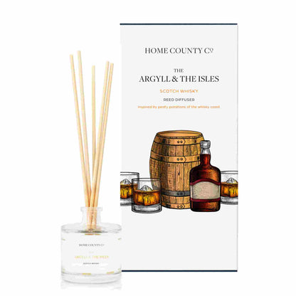 A scotch whisky scented reed diffuser from Home County Co. The vegan friendly reed diffuser is shown next to the eco friendly reed diffuser box packaging.