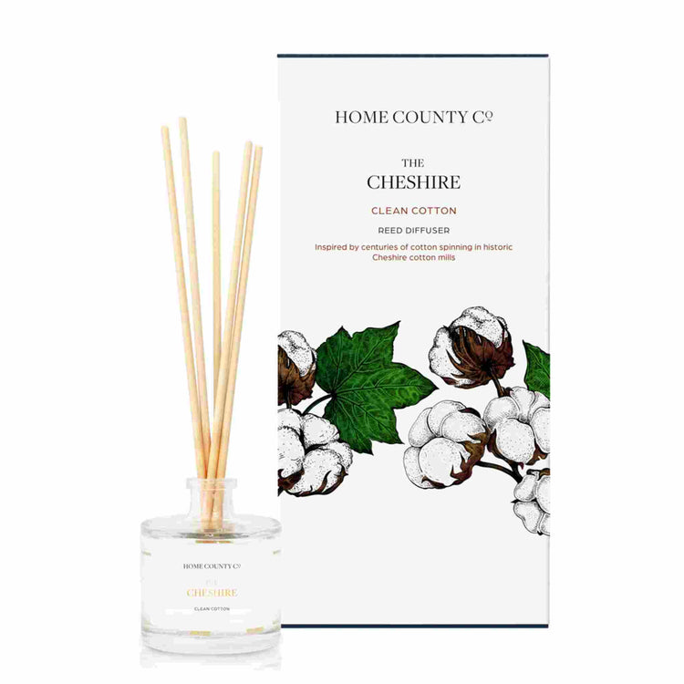 A clean cotton scented reed diffuser from Home County Co. The vegan friendly reed diffuser is shown next to the eco friendly reed diffuser box packaging.