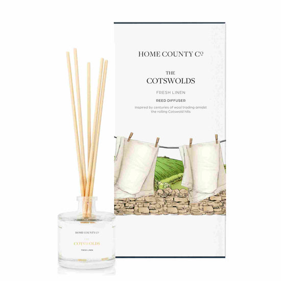 A fresh linen scented reed diffuser from Home County Co. The vegan friendly reed diffuser is shown next to the eco friendly reed diffuser box packaging.