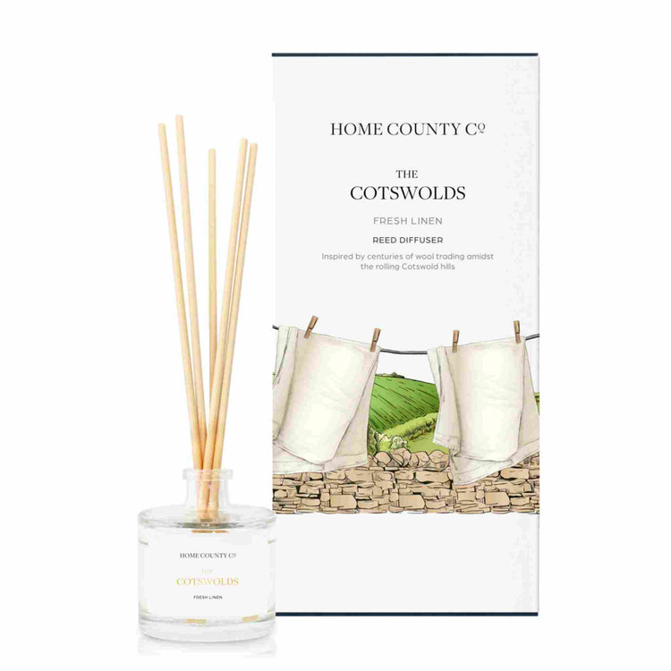 A fresh linen scented reed diffuser from Home County Co. The vegan friendly reed diffuser is shown next to the eco friendly reed diffuser box packaging.