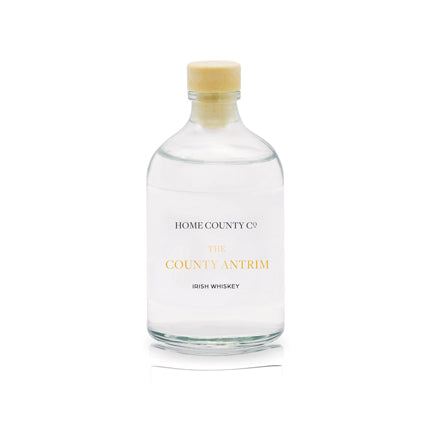 An Irish whiskey scented reed diffuser refill from Home County Co. The eco friendly reed diffuser refill is shown in its recyclable glass bottle.
