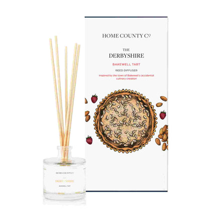 A Bakewell tart scented reed diffuser from Home County Co. The vegan friendly reed diffuser is shown next to the eco friendly reed diffuser box packaging.