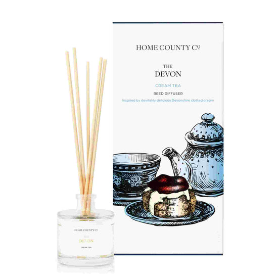 A cream tea scented reed diffuser from Home County Co. The vegan friendly reed diffuser is shown next to the eco friendly reed diffuser box packaging.