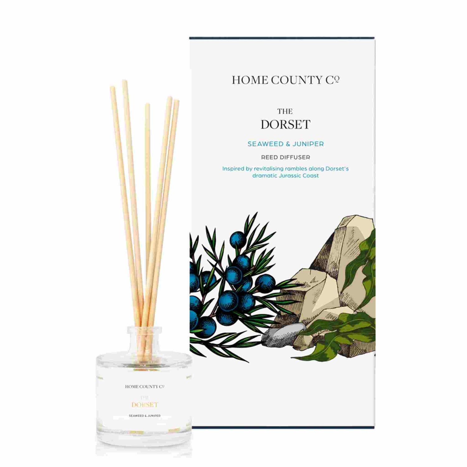 A seaweed and juniper scented reed diffuser from Home County Co. The vegan friendly reed diffuser is shown next to the eco friendly reed diffuser box packaging.