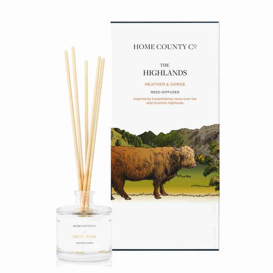 A heather and gorse scented reed diffuser from Home County Co. The vegan friendly reed diffuser is shown next to the eco friendly reed diffuser box packaging.
