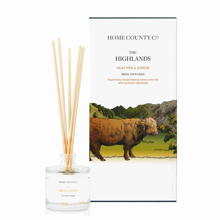 A heather and gorse scented reed diffuser from Home County Co. The vegan friendly reed diffuser is shown next to the eco friendly reed diffuser box packaging.