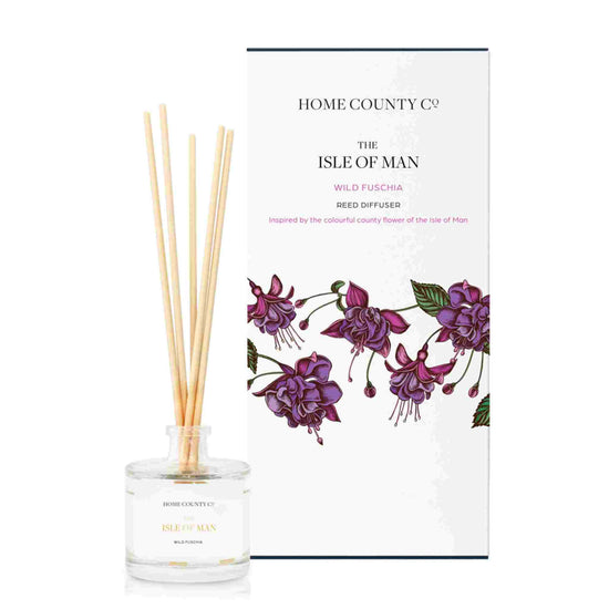 A wild fuchsia scented reed diffuser from Home County Co. The vegan friendly reed diffuser is shown next to the eco friendly reed diffuser box packaging.