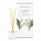 A lily of the valley scented reed diffuser from Home County Co. The vegan friendly reed diffuser is shown next to the eco friendly reed diffuser box packaging.