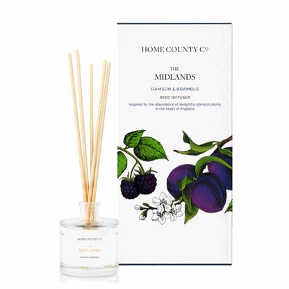 A damson and bramble scented reed diffuser from Home County Co. The vegan friendly reed diffuser is shown next to the eco friendly reed diffuser box packaging.