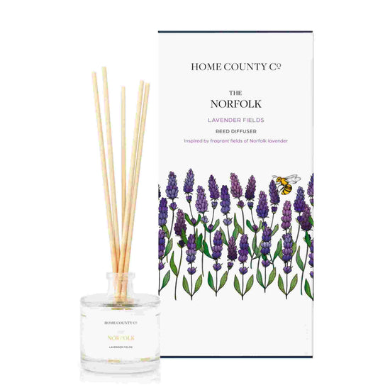 A lavender fields scented reed diffuser from Home County Co. The vegan friendly reed diffuser is shown next to the eco friendly reed diffuser box packaging.