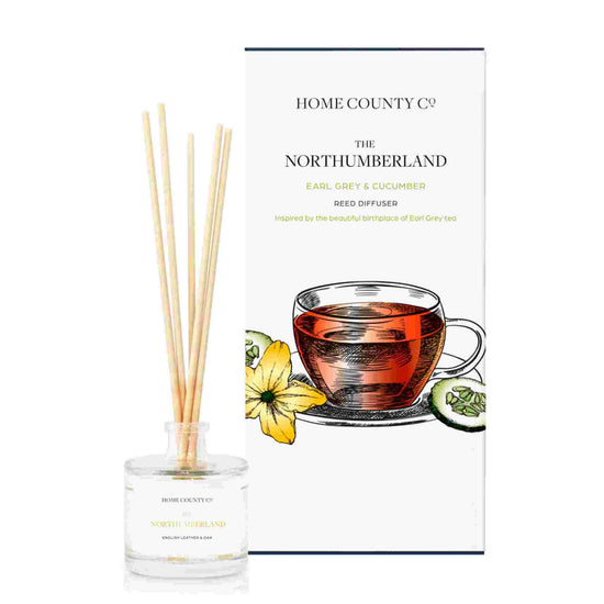 An earl grey and cucumber scented reed diffuser from Home County Co. The vegan friendly reed diffuser is shown next to the eco friendly reed diffuser box packaging.