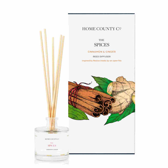 A cinnamon and ginger scented reed diffuser from Home County Co. The vegan friendly reed diffuser is shown next to the eco friendly reed diffuser box packaging.