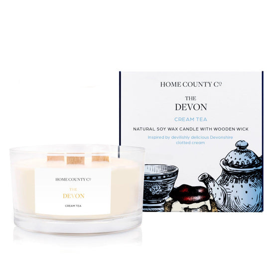 A cream tea scented 3 wick candle from the Home County Co. is shown next to its eco-friendly candle packaging box. 