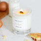 A Derbyshire Bakewell Tart scented candle is shown alight on a kitchen worktop
