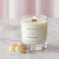 A Prosecco and Pomelo scented candle from the Home County Co is shown alight next to white chocolates